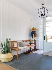 lake house entryway slate floors white board and batten and light wood entry bench