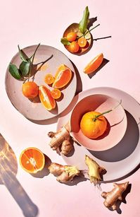 tangerines on pink backdrop in ceramic dishes. / sfgirlbybay