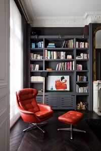 La poltroncina vintage in pelle rossa degli Anni 60.libreria color grigio antracite