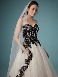 Feel like a mystical fairytale princess in this ballgown wedding dress, adorned with dramatic black lace. #blackweddingdress #whimsicalweddingdress #coloredweddingdress #MaggieSottero