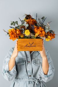 Sosteniendo un macetero con flores preservadas de Brotavia