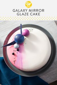 A sweet and shiny glaze tops this Galaxy-Inspired Mirror Glaze Cake, giving it a glossy finish that’s out of this world! Great for birthdays, showers or just because, this mirror glaze cake features glazes in three colors and is topped with edible accents. #wiltoncakes #mirrorglazecake #cake #birthdaycake #cakedecorating #candymelts #galaxycake