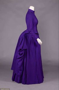 2-pc twill wool day dress w/ standing collar, fitted Basque bodice w/ extended back panel & asymmetrical side drape, 2-pc fitted sleeves, faux marcasite floret buttons, double watch pockets w/ crows foot embroidered details, printed cotton lining in grape leaf & vine motif, B 35", W 26", L 18.5"-49", skirt W 27", L 40", (lining stained, scattered tiny holes, 1 button missing fro cuff, 0.75" tear at seam of left pocket, 0.75" hole at left swag) very good-excellent.