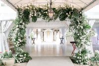Leaf + Petal NOLA used neutral lilies, hydrangeas, garden roses, majolica, and lush tropical greens to create a dramatic entrance to the tent at Old Ursuline Convent in New Orleans for a garden wedding reception.