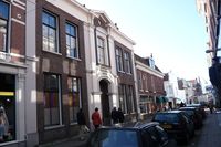 Barrevoetestraat 4 A t/m F (Wijnbergshofje), Haarlem Inleiding Het WijnbergsHOFJE is in de zeventiende eeuw gesticht maar dateert in zijn huidige vorm grotendeels uit 1872. Het achterhuis met de voormalige regentenkamer en een lijstgevel in regencestijl vormt het restant van een oudere bouwfase. Het kleinschalige hofje ligt achter het hoofdgebouw in Eclectische trant aan de straatzijde en heeft een rechthoekige hoofdvorm rond een eenvoudige binnentuin met centraal rechthoekig beplantingsvak.