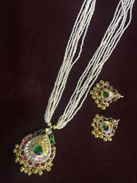 Kundan Jewellery sets including kundan mala and earrings embossed with green gemstones and clusters around the diamond pendant. Check more about it at https://www.madhurya.com/jewellery/kundan-jewellery.html #kundanjewellerysets #kundannecklace