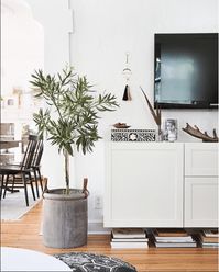 I'm sharing tips for how to decorate around a TV so that the tv isn't the focal point of a wall. Ideas such as adding a shelf for under a wall mounted TV, what to put under the mounted TV, decorating ideas above the tv and more!