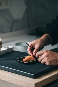 El chef Matía L. Meza preparando un Nigiri de salmón durante un servicio a domicilio