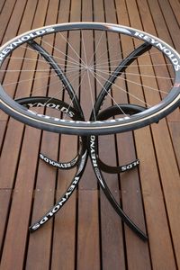 table from old bike rims. Add a bottle cap top and put it in the man cave/bike shop. Someday.