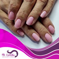 Manicura de uñas con esmalte permanente color rosa pastel.
