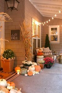 Cozy and natural fall porch decorating ideas. Create a welcoming front porch using pumpkins, cornstalks and candles.