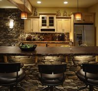 Cool idea for basement kitchen/bar. I love the stools and under-bar lighting!