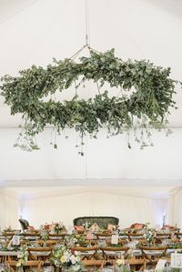 2018 wedding trends are going to include hanging floral wreaths, like this bespoke greenery chandelier in our Dana Pearl tent, with rustic furniture to match.
