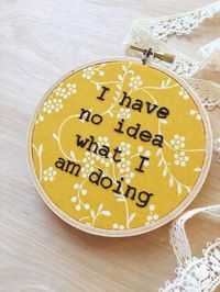 OVERVIEW - This hilarious phrase is hand embroidered in black on a mustard and white floral print cotton fabric. - Stretched and framed in a 4 inch round embroidery hoop. (See last photo for scale) - Embroidery hoop is backed with card stock to protect the backside. (See photos above