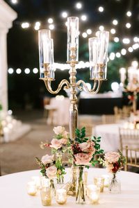 Leaf and Petal accented the base of brass candelabras with a trio of garden style bud vases with garden roses, ranunculus and greenery at a wedding reception at the Elms Mansion in New Orleans