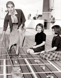 Grace Kelly playing shuffleboard with her nieces looking on. They are on board the ship ( S S Constitution ), en route to Monaco, for her wedding in 1956.