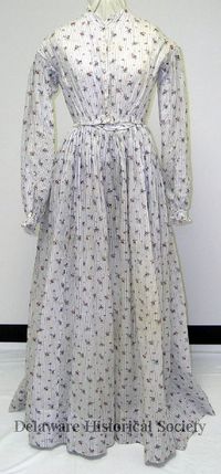 The dress Jane wore when Frank Dawson first kissed her in The Soldier's Love. A full-length day dress of white organdy printed with a small repeating pattern of pink and blue flower sprigs with a vertical brown stripe. 1860-1870 Delaware Historical Society