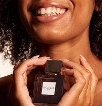 A young woman holds a bottle of Sillages perfume. This is one of the best places to create a custom perfume in Paris
