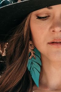 Bridal feather leather tooled earrings created by @caseycurtisdesigns western boho cowgirl wedding shoot by @ladywestphotography