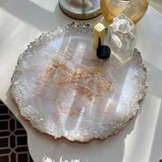 This may contain: a table topped with a large white plate covered in gold flecks next to a candle holder : Aartsywish - aartsywish - resin tray 