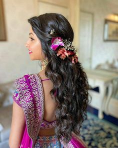 the elegant open hair look with bright flowers to match the lehenga.