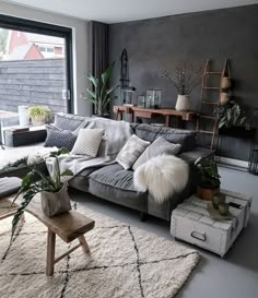 Stone wall, patterned rug, wood furnishings, rustic elements, bohemian inspired, crate side table, plant life, contemporary eclectic design Masculine Living Rooms, Living Room Inspiration, Apartment Decor