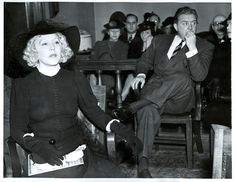 LOS ANGELES, CALIF:--Mae Murray, above, is shown in court where she is seeking $ 1,000 a month from her former mate, Prince David Mdivani, seated background, to support their child, who is in custody of "strangers" at a farm-home near Albany, N.Y. The Prince charged from the witness stand that Miss Murray did not ask for money for their son, Koran David Mdivani, 13, but for herself. Angeles, Donovan, David