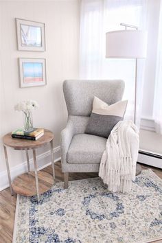Rincón de lectura con sillón gris en salón neutro beige