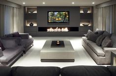 Grande living moderno con camino e tv. Stupenda illuminazione libreria e camino chiuso. Modern Living Room, Trendy Living Rooms, Furniture Ideas