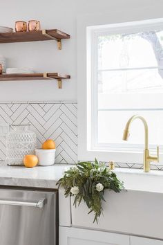 Matte Gl Herringbone Tiles Make For A Beautiful Backsplash A Farmhouse Sink With Brushed Gold Gooseneck Faucet Is Positioned Beneath Window Partially Framed