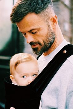 man carrying baby in sling