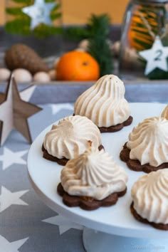 there are cookies with white frosting on the plate and star decorations in the background