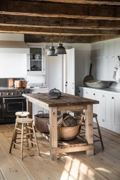 One side of the kitchen is lined with peg rails. The round baskets beneath the island store clean dish towels. The wooden stools were another Marston House find, and the wire baskets were sourced from Trillium Soaps in Rockland, Maine, which also sells a selection of housewares. Rustic Country Kitchens, Farmhouse Kitchen Island, Modern Farmhouse Kitchens, Home Kitchens, Kitchen Islands, Small Kitchens, Kitchen Rustic, Modern Kitchen, Vintage Kitchen