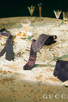 The silk tie is embellished with some of the House's most recognizable codes, including the interlocking G, bee, hearts and stars.