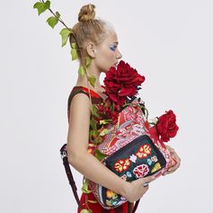 This red bag could be in an art gallery, but it’s better in your wardrobe. A vertical shape bag with a single handle and floral picture with colourful frieze patterns, front pocket with floral embroidery with zip and embroidered removable strap for using it as a messenger bag. Measurements: 29 x 12 x 37 cm.