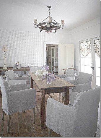 A beautiful spare shabby chic dining area with linen slipcovered dining chairs and a narrow farm table at The Prairie by Rachel Ashwell. #theprairie #shabbychic #RachelAshwell
