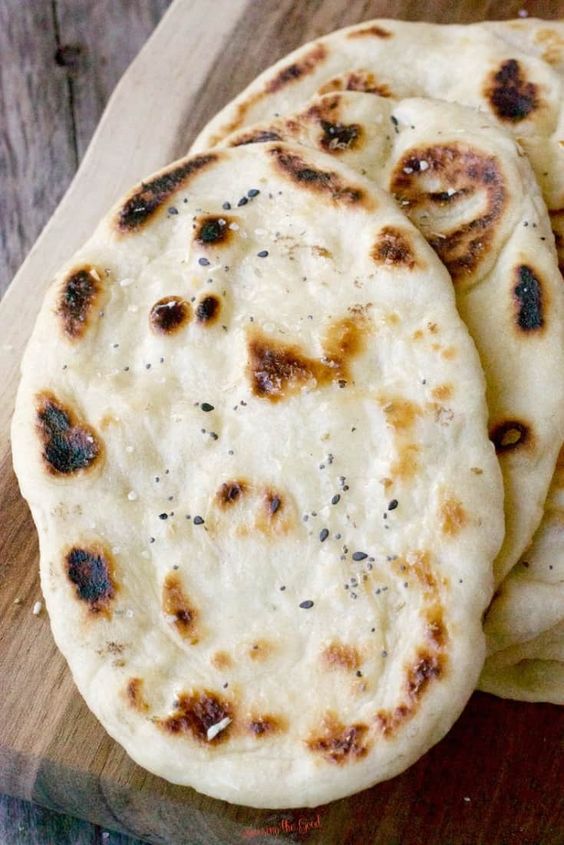 Naan is a traditional Indian flat bread that is pillowy soft and delicious. This easy naan bread recipe calls for plain yogurt, egg and is brushed with melted butter when the naan comes off the cast iron skillet. Homemade naan bread will outshine sore bought every time.