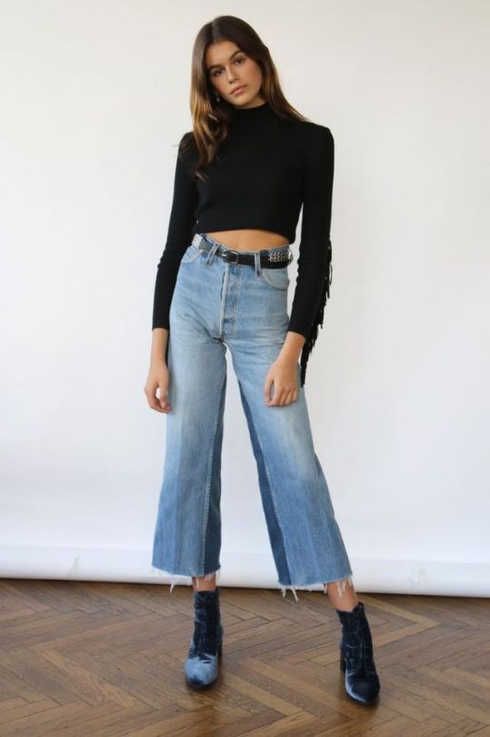 O estilo de Kaia Gerber. Blusa de manga e gola alta, calça jeans cropped, ankle boot de veludo, cinto preto