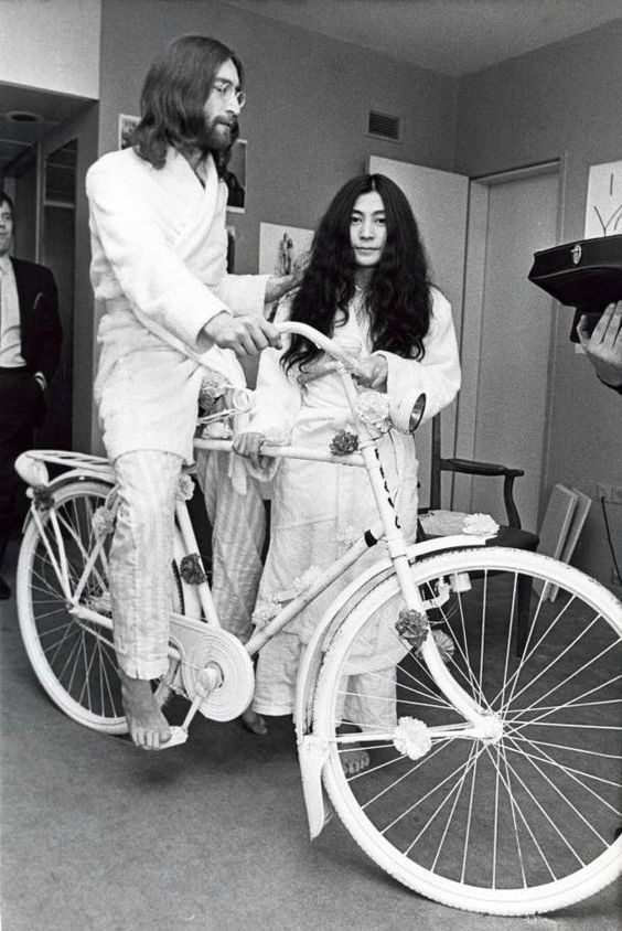 John Lennon with Yoko Ono, riding a bike inside the Hilton Hotel. Photo by Ruud Hoff