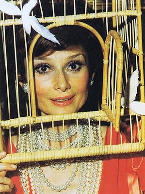 Audrey Hepburn wearing a Magritte bird cage at the diner des testes surrealistes, 1972