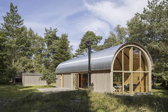 A Curved Corrugated Metal Roof Creates An Impressive Vaulted Ceiling Inside This Cabin