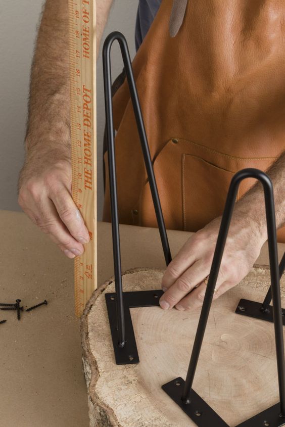 Measuring to be sure where to add the hairpin legs to the easy DIY live edge table. Learn how with our step by step tutorial...