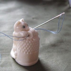 Carved Kitty Cat playing with spool of thread on top of a thimble. Needle and thread saver also. One of a kind hand crafted collectible sewing thimble by Brad Elfrink.