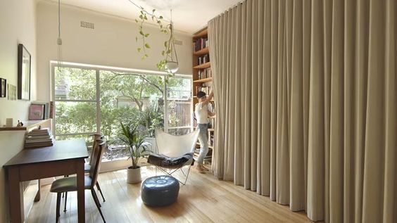 A Floor-To-Ceiling Curtain Hides A Wall Of Storage And Bed In This Small Apartment