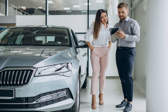 Premium Photo | Young business woman buying a car in car showroom