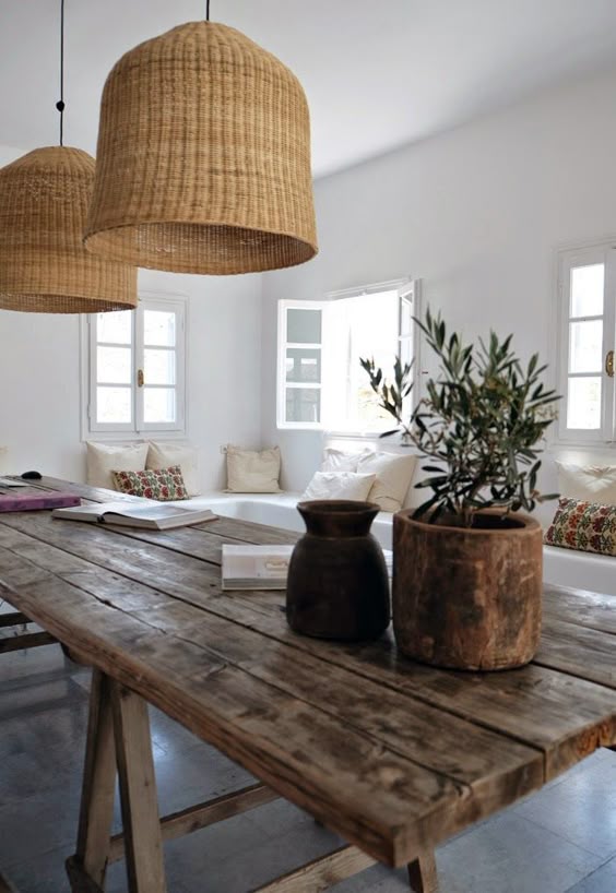 Rustic decor in a farmhouse dining room and living area with builtin benches. #rusticdecor #farmhouse #farmtable #wickerpendant