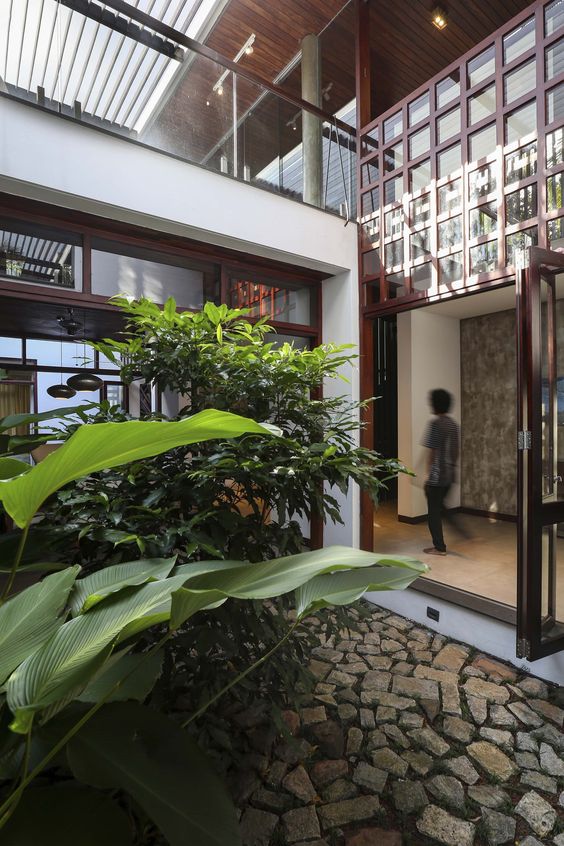 The Wall of Being - The residence stands at a y - junction in a dense residential neighbourhood of Kozhikode, a coastal city in the south Indian state of Kerala, on a linear plot deprived of views to the outside. The client’s personality embraces a modern lifestyle, at the same time are very nostalgic about their ancestral village of the central Malabar region. The process culminated in the idea of making spaces that evoke one’s collective memory of the region, at the same time relying on modern