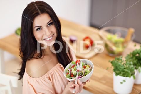 Happy Woman Preparing Salad In Modern Kitchen Stock Photos Ad