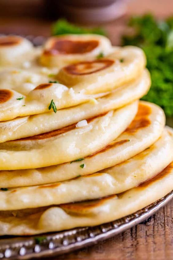 Homemade Naan Bread Recipe from The Food Charlatan. Make restaurant quality Naan Bread at home! If you have never tasted a fresh, tender, buttery homemade naan, you\'re totally missing out. I will show you just how easy this recipe is to put together and gives you the perfect receptacle for cleaning up all the curry on your plate!
