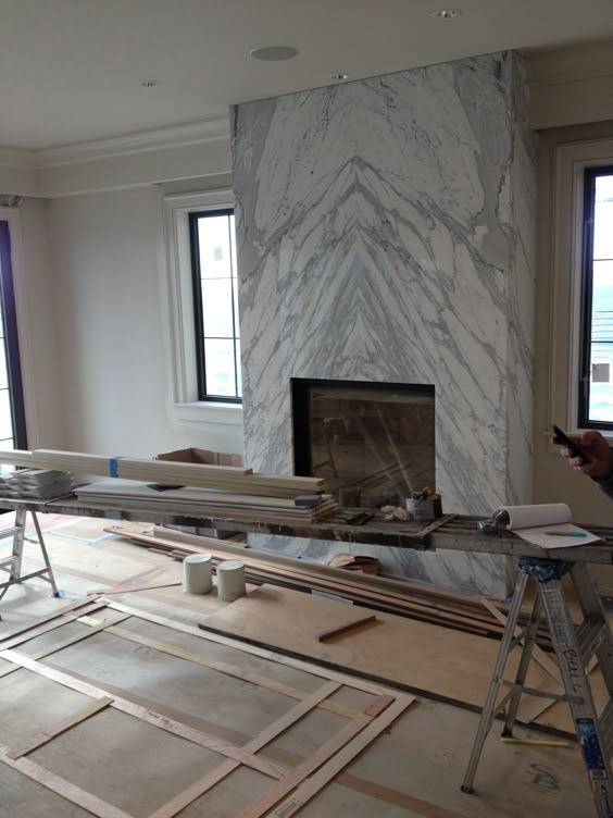 contemporary slab stone fireplace, calacutta carrara marble, book matched stone slab, gas fireplace insert, raised box, interior design by dixiestark.com